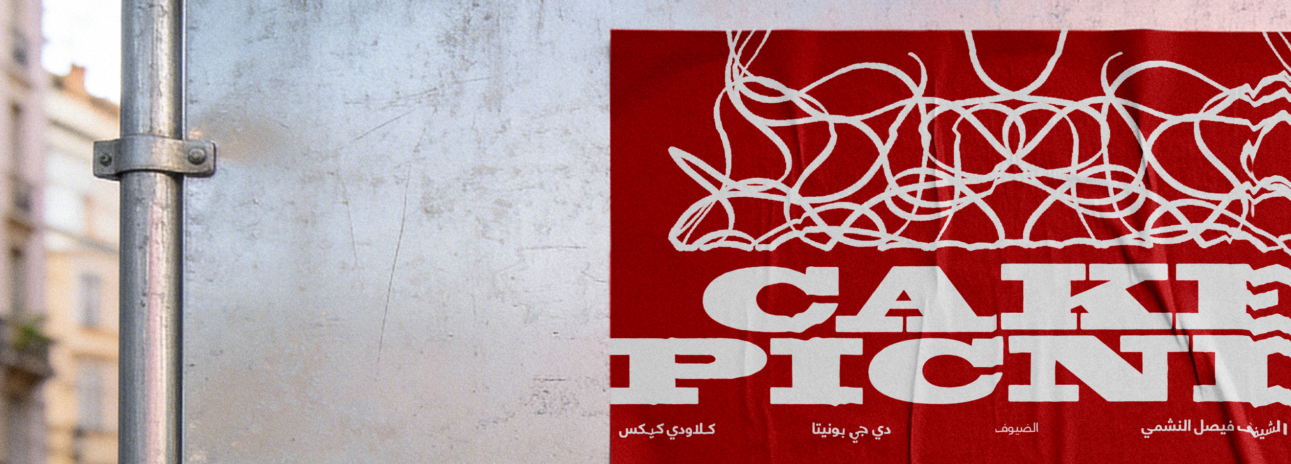 Close-up of a red Cake Picnic poster installed on a city wall